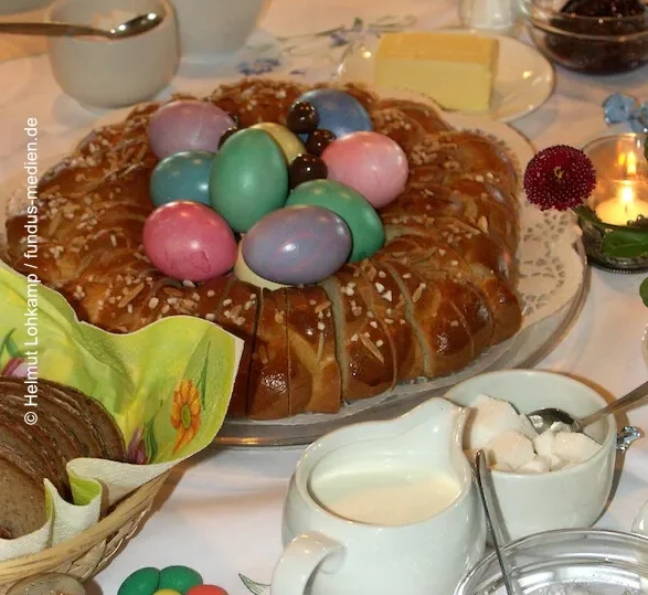 gedeckter Tisch mit Ostereiern und Osterzopf